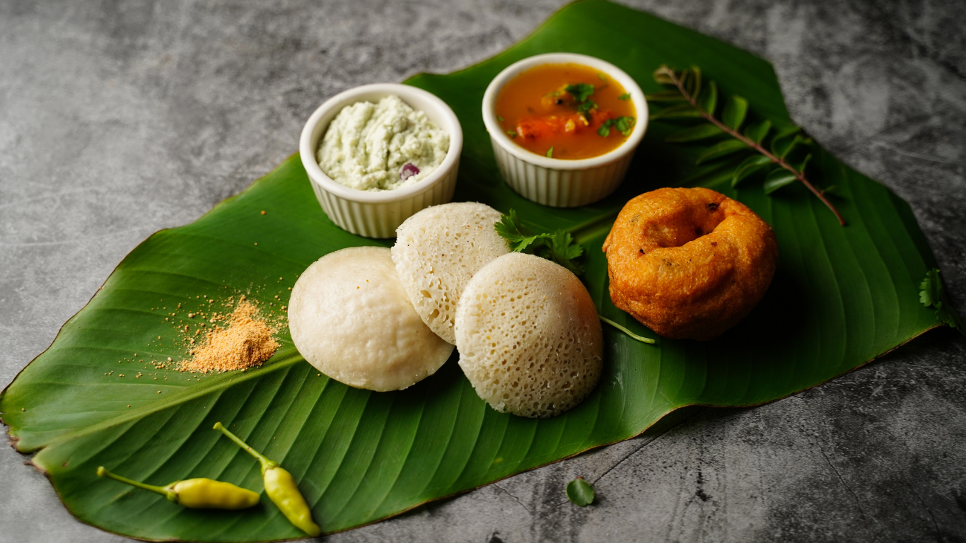 Indian snacks displayed on a banana leaf with chutneys